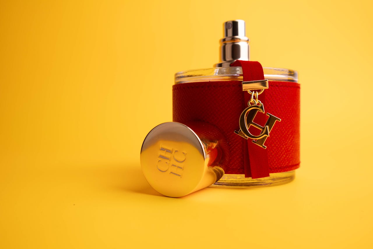 services-01 Stylish red perfume bottle with gold detailing on a bright yellow backdrop, ideal for luxury advertising.